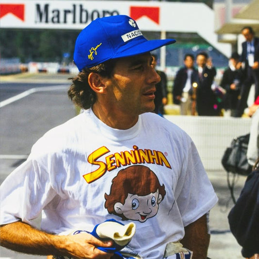 Senninha t-shirt with a cartoon character, standing on a track