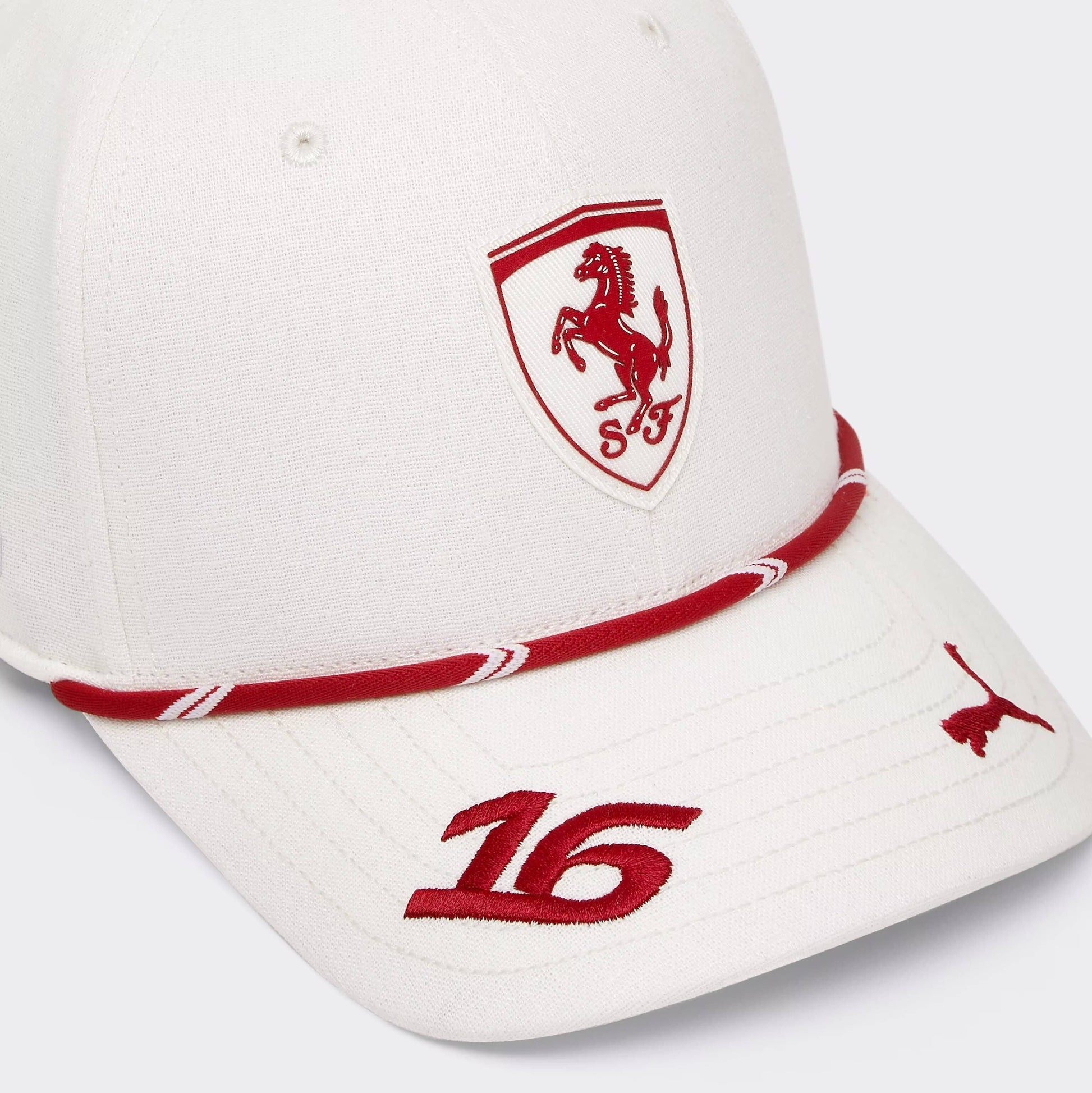 A white baseball cap featuring the red Ferrari Scuderia Ferrari shield logo on the front, a red and white rope detail around the brim, and the number 16 embroidered on the brim.
